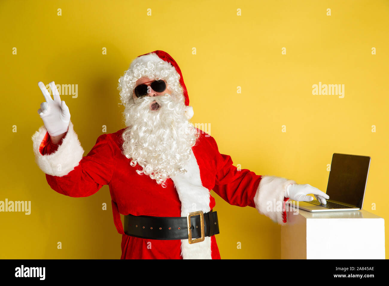 Santa Using Technology Image Santa Claus with modern gadgets isolated on yellow studio background ...