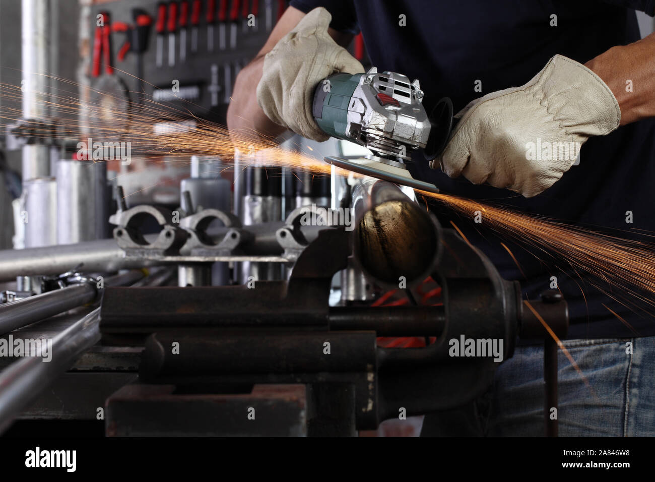 hands man work in home garage with angle grinder, goggles and construction gloves