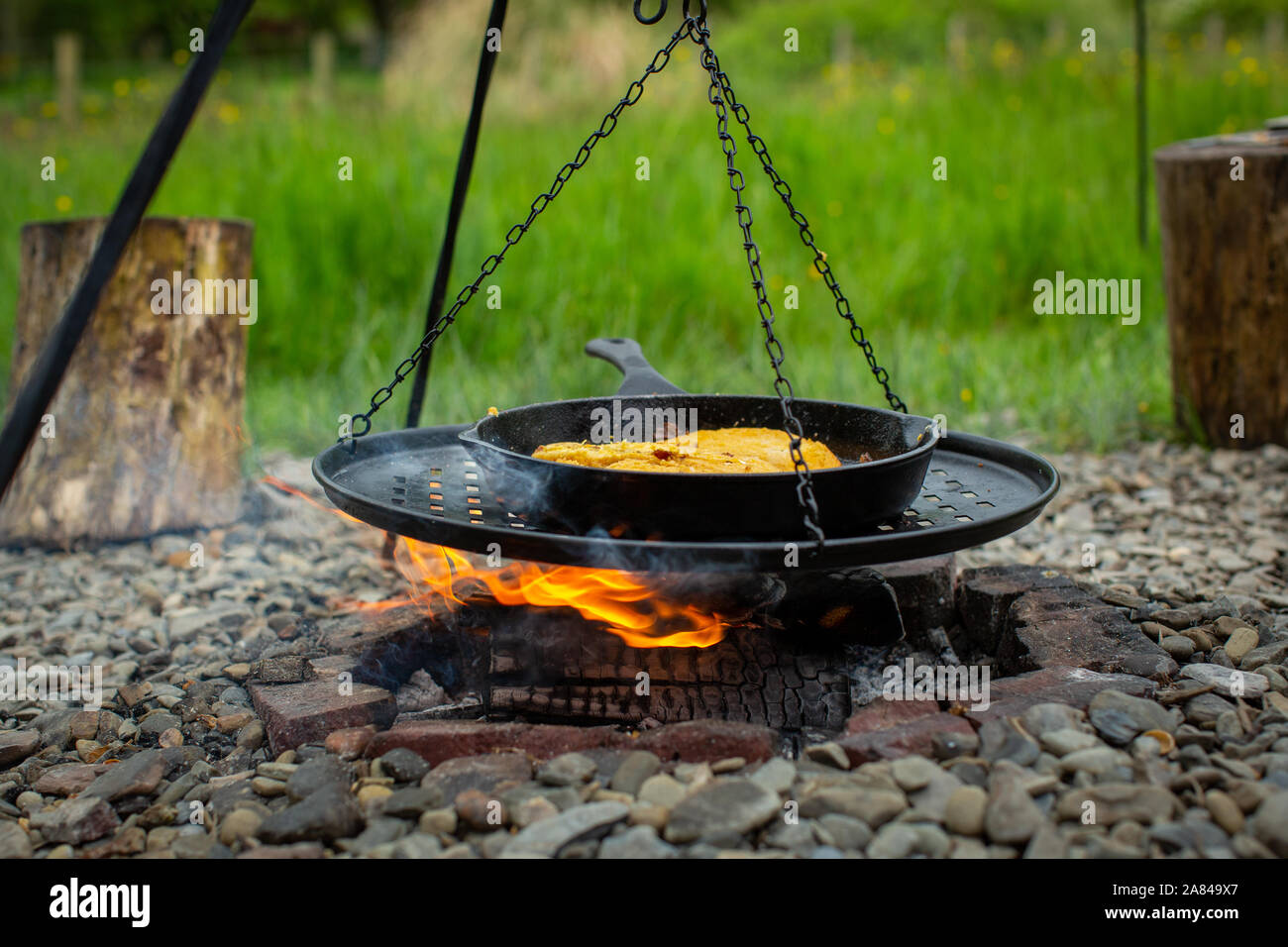Eggy bread cooking in a cast iron frying pan on an open fire Stock