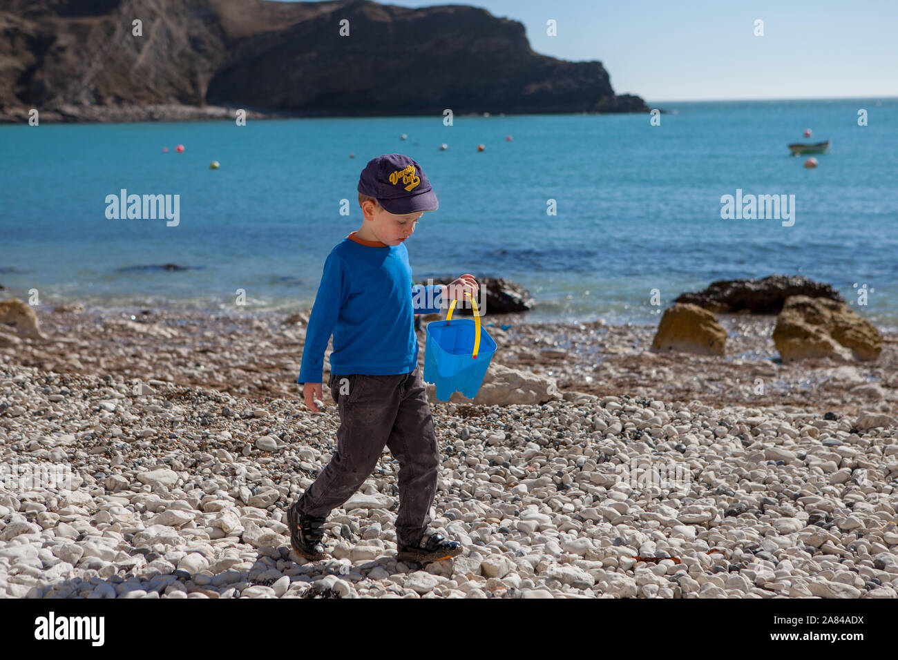 A young boy playing with his bucket and spade on the beach, England ...