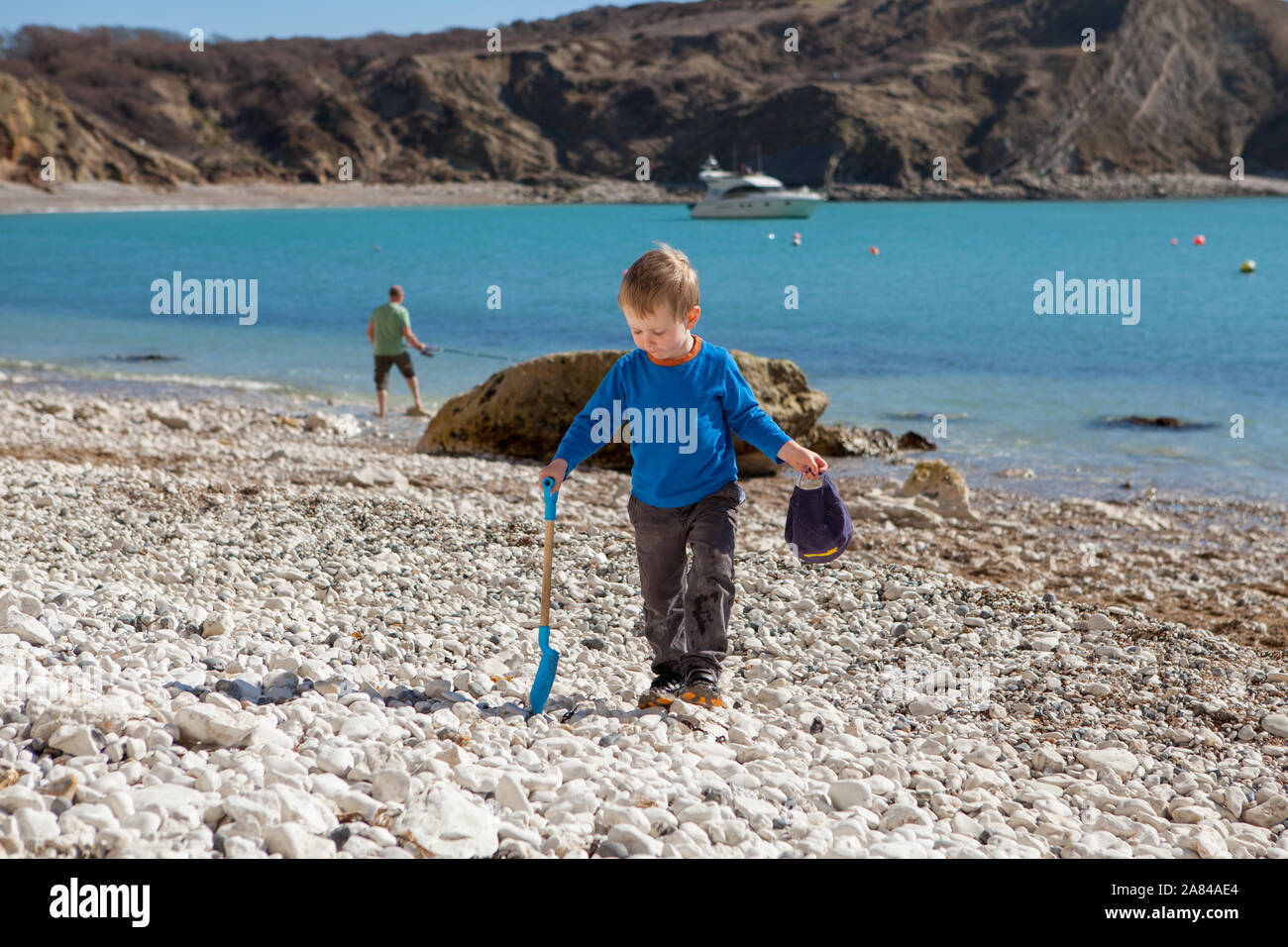 A young boy playing with his bucket and spade on the beach, England ...