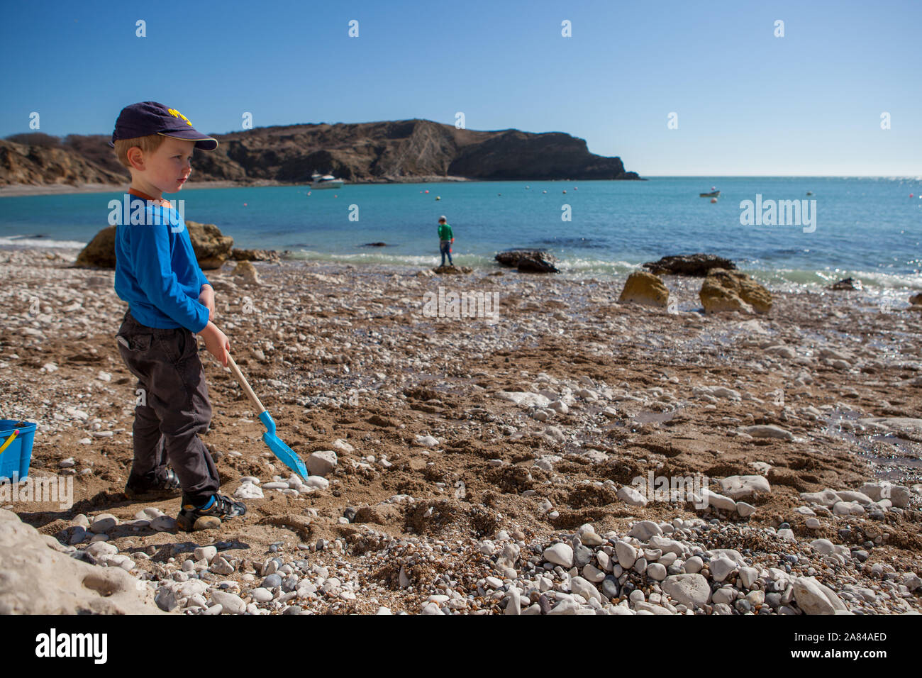 A young boy playing with his bucket and spade on the beach, England ...