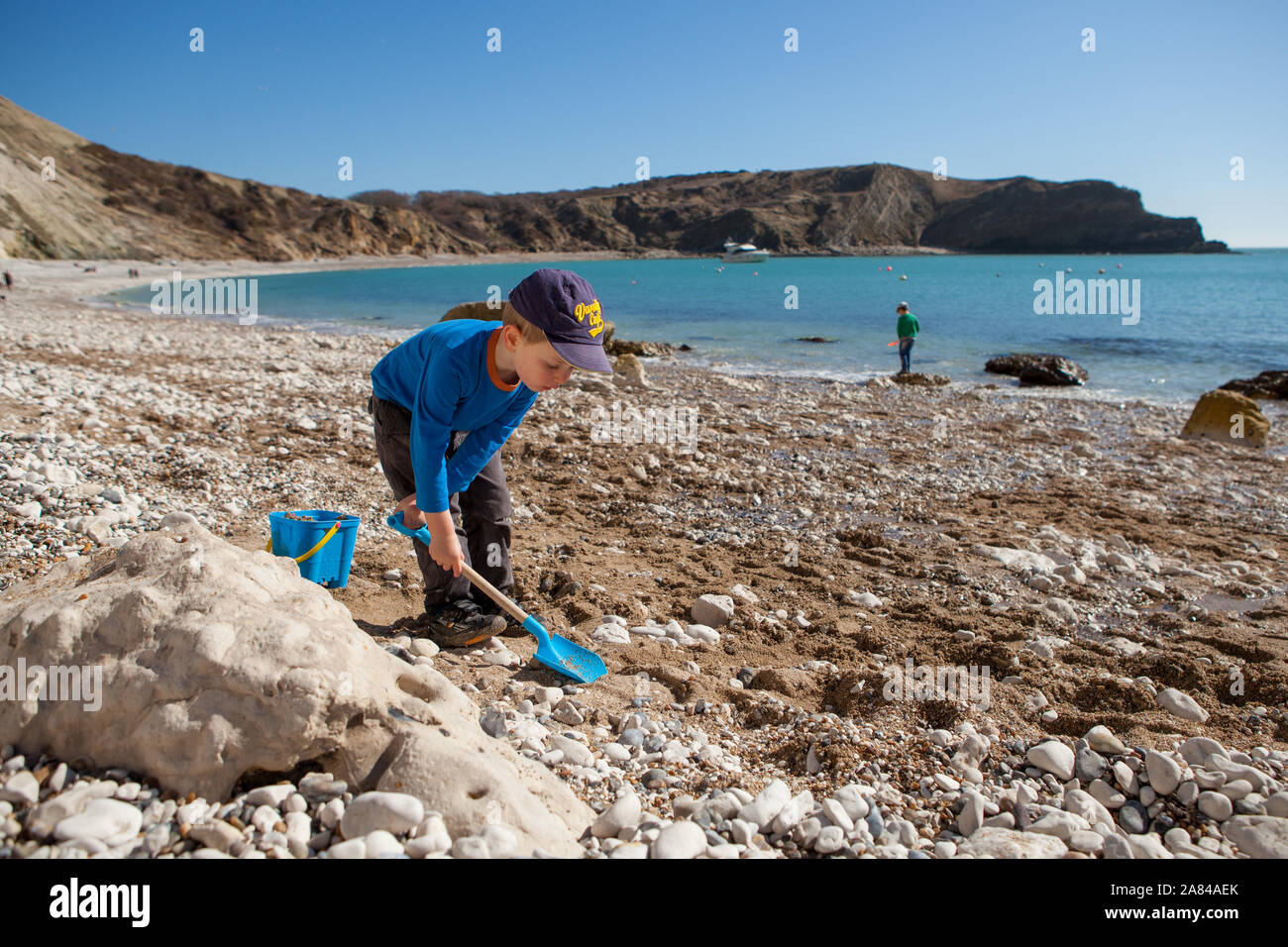 A young boy playing with his bucket and spade on the beach, England ...