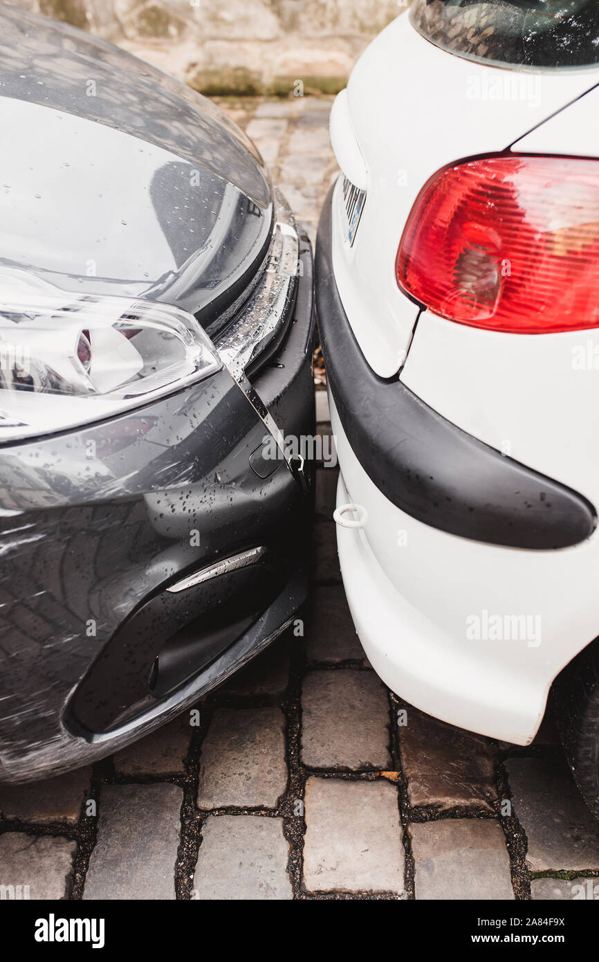 Dense parking on busy city streets two cars are touching each other
