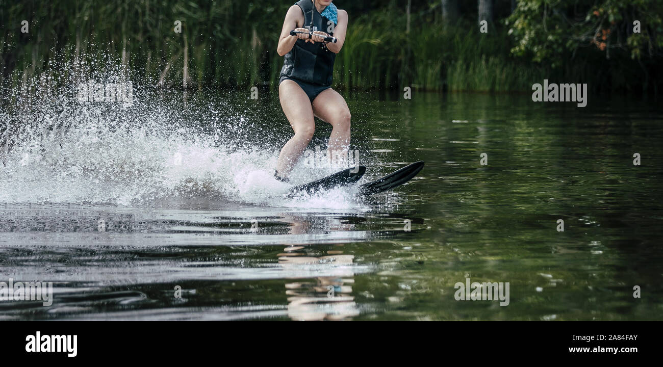 wakeboarding female rider in wakeboard in summer on lake Stock Photo