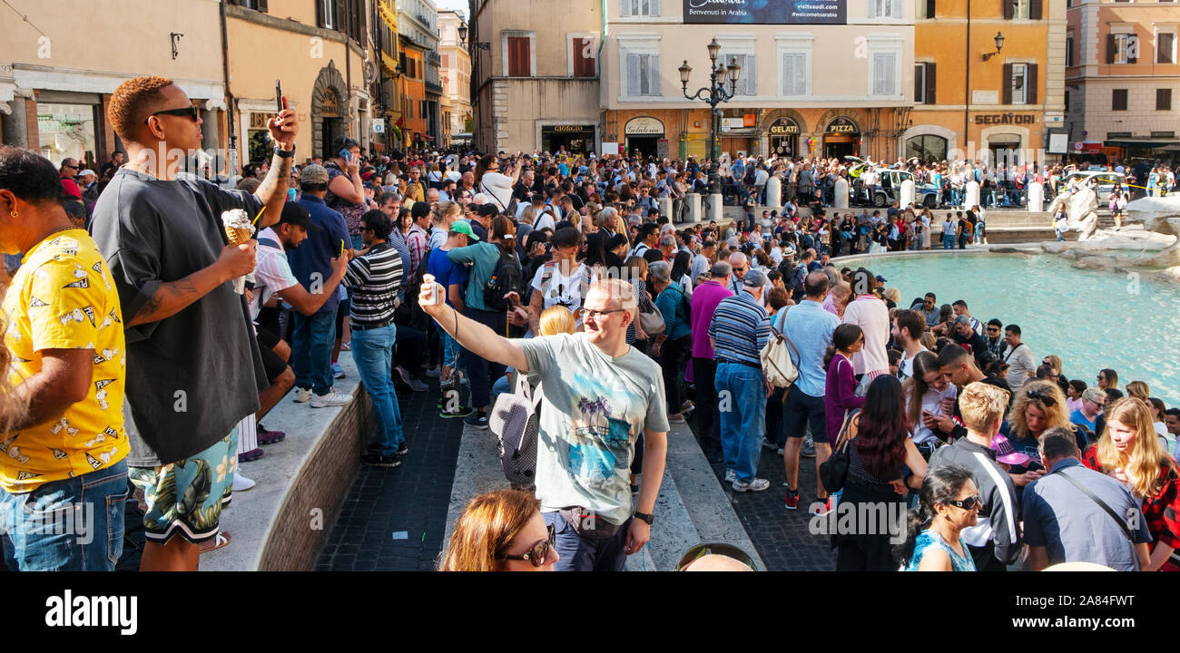 ROME, ITALY - OCTOBER 13, 2019: A crowd of tourists at the famous Trevi Fountain or Fontanta di Trevi, in Rome, Italy, taking pictures or waiting to t Stock Photo