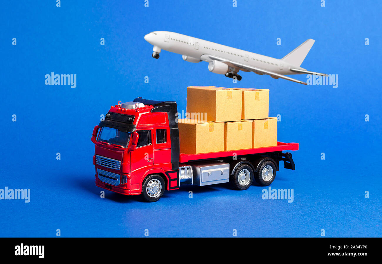 A red truck with boxes and cargo plane. Goods transportation services company. Logistics and infrastructure. Warehousing and supply. Optimization of d Stock Photo
