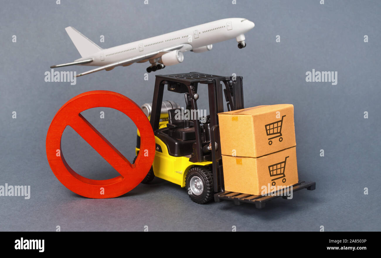 Yellow Forklift truck carries boxex and a red prohibition symbol NO. Embargo trade wars. Restriction on importation production, ban on export of dual- Stock Photo