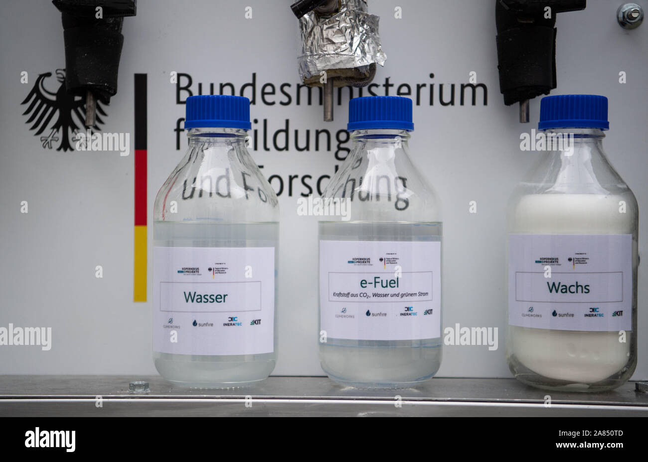Eggenstein Leopoldshafen, Germany. 06th Nov, 2019. Bottles containing water, e-fuel and synthetic wax are located on the northern campus of the Karlsruhe Institute of Technology (KIT) in a research facility that can produce CO2-neutral fuel from air and green electricity using "Power-to-X" technologies (P2X). The plant was officially put into operation. Credit: Marijan Murat/dpa/Alamy Live News Stock Photo