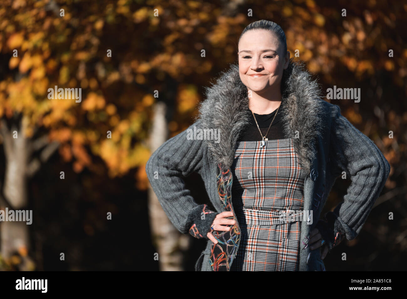 Portrait of a beautiful woman in her 40's with autumn leafs and colours in background Stock Photo