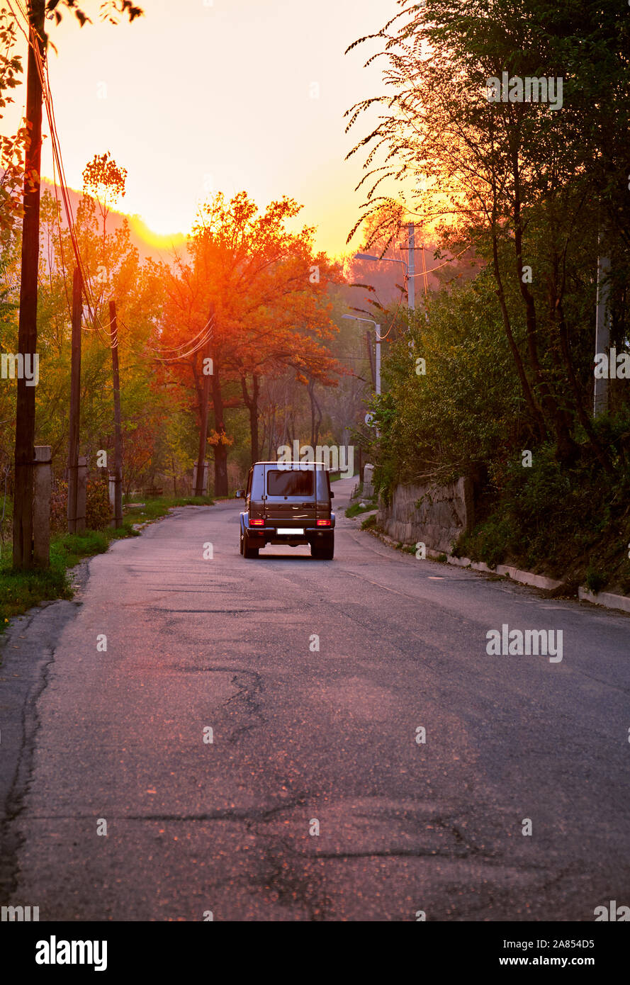 Black crossover car driving on the countryside asphalt road against a ...