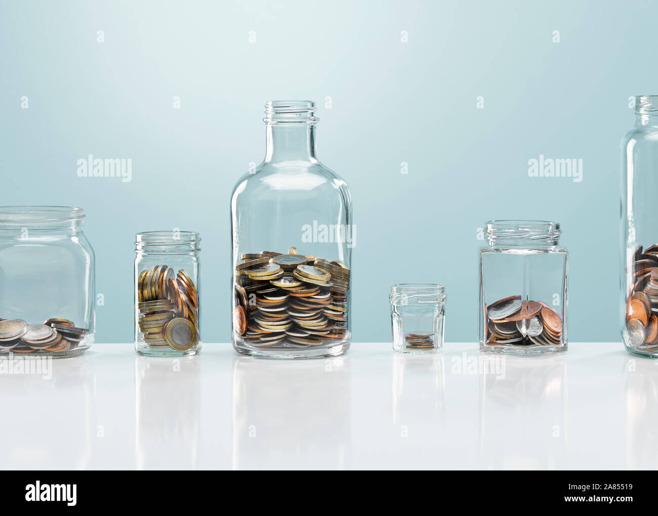 Coins in variety of glass bottles Stock Photo Alamy