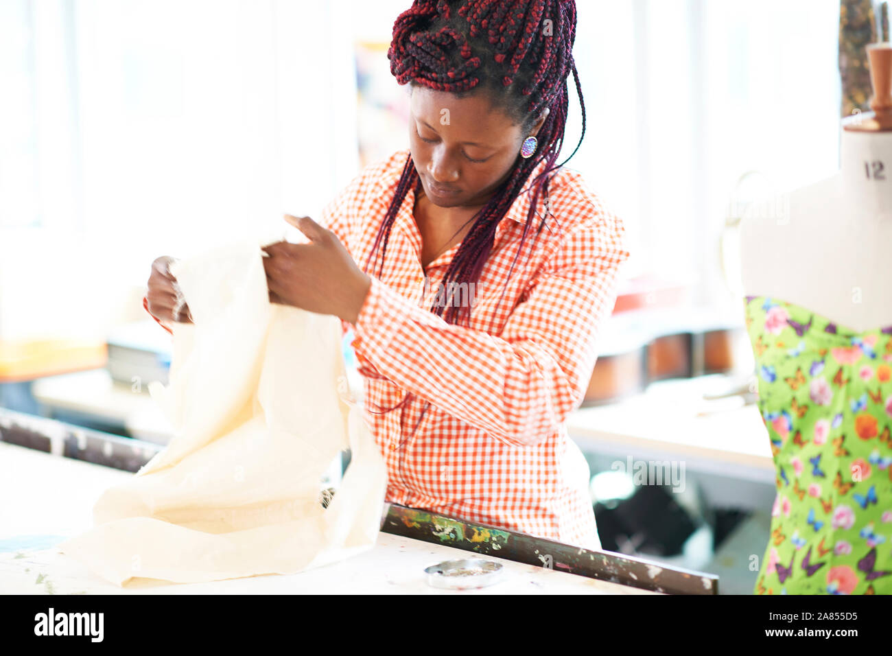 Female fashion designer with fabric in studio Stock Photo