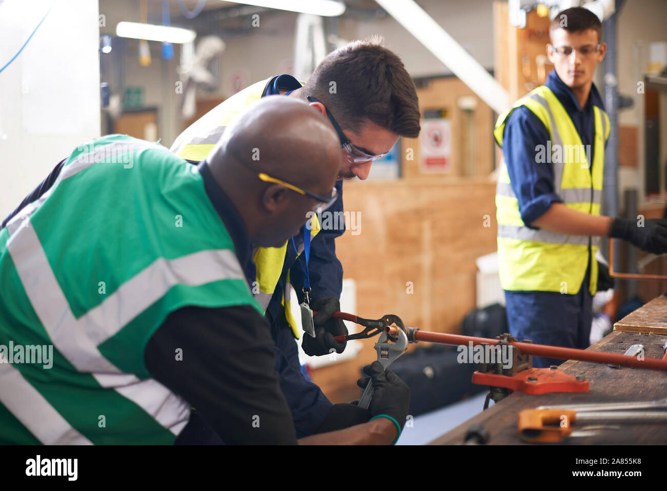 Male instructor helping students in shop class workshop Stock Photo