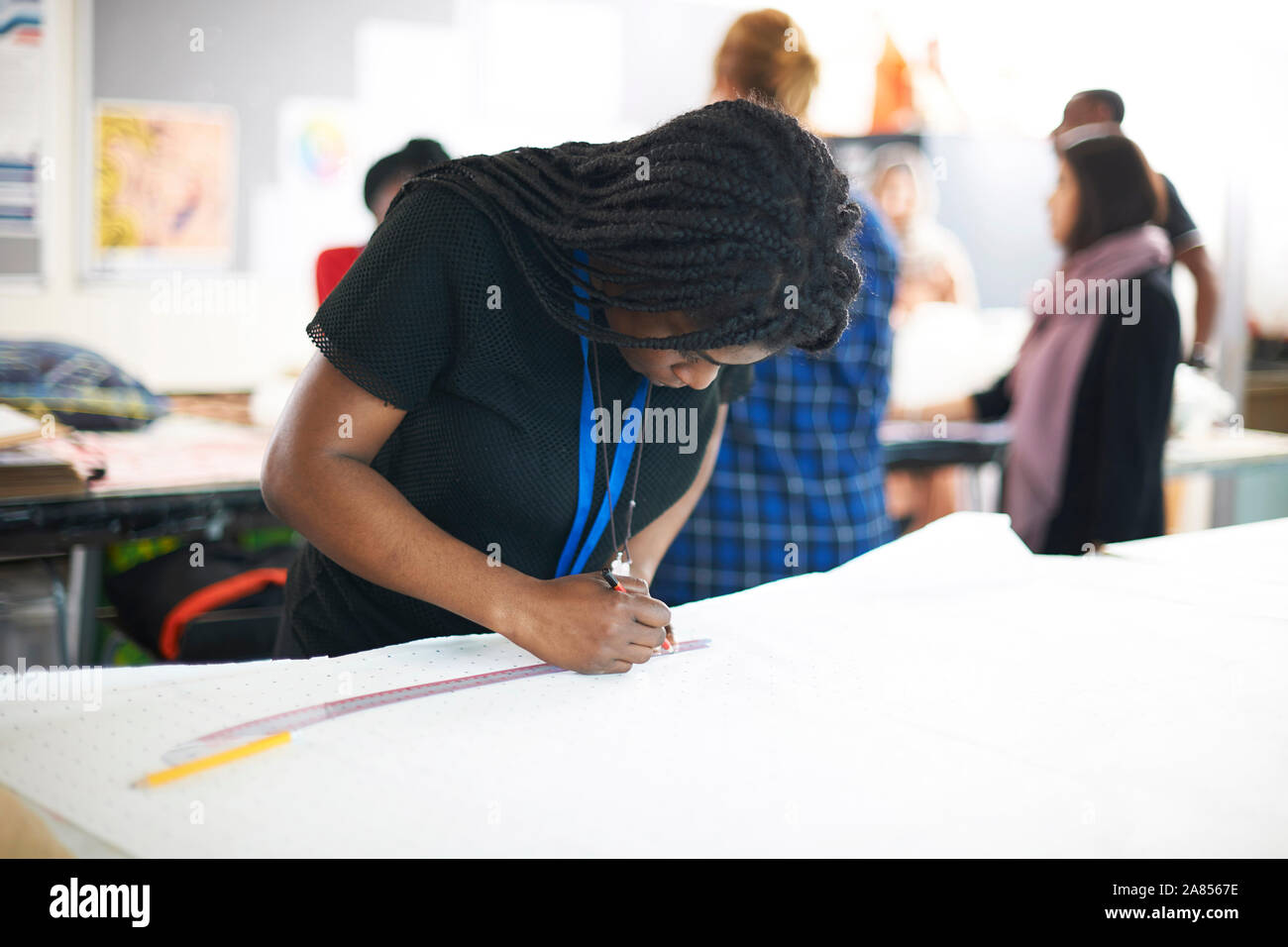 Focused female fashion designer drawing sewing pattern in studio Stock Photo