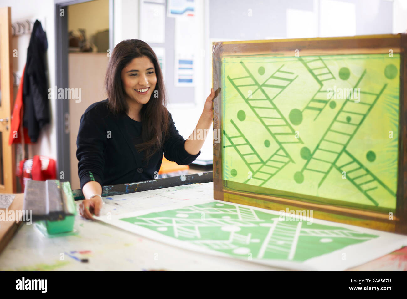 Smiling female art student screen printing in art studio Stock Photo Alamy