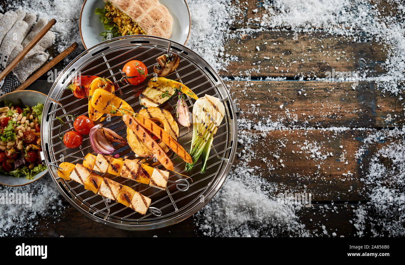 Assorted farm fresh vegetables grilling on a BBQ outdoors in winter