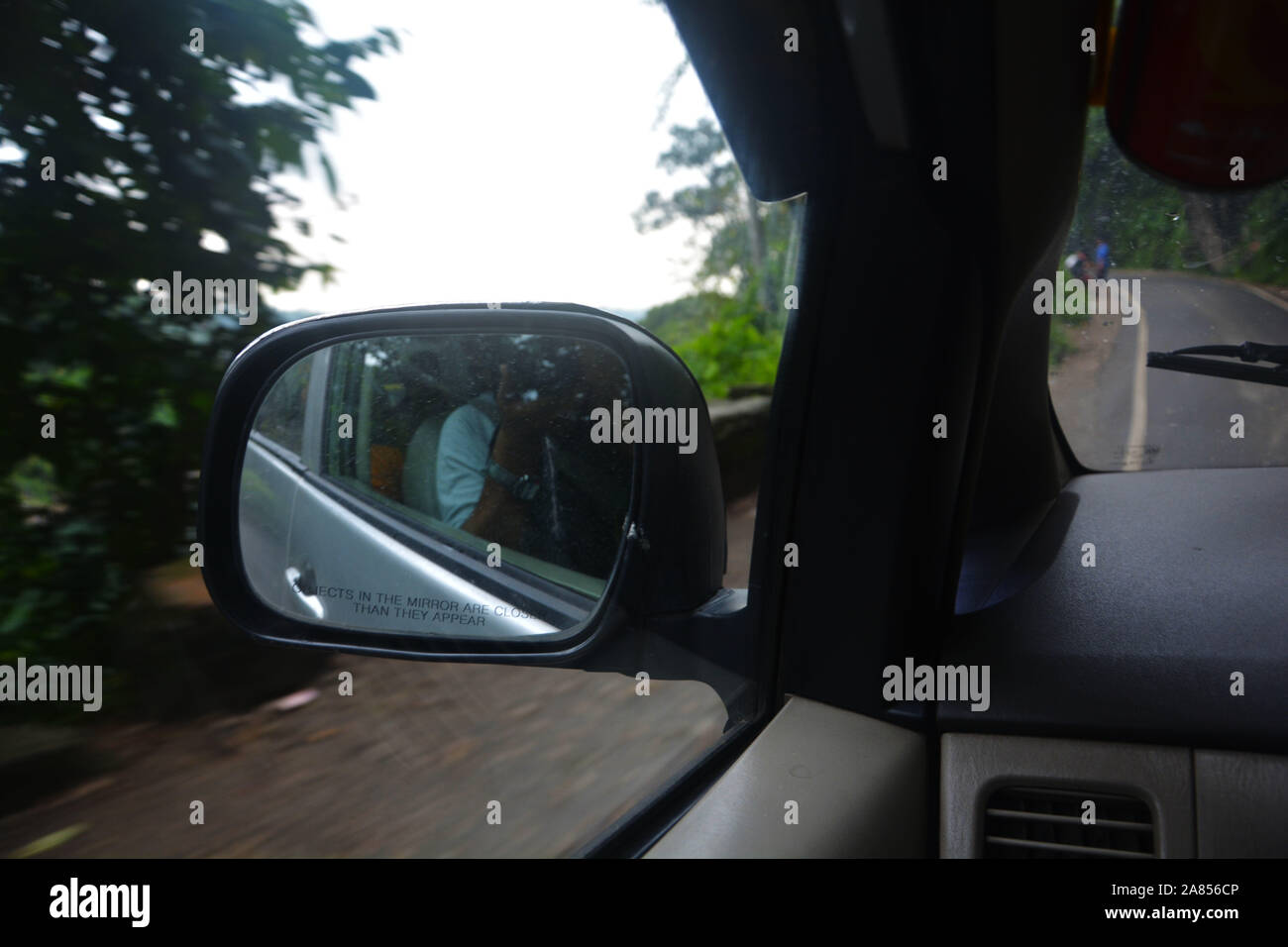 Close up of a looking glass of a car in motion from the front seat with reflection of the back view of the car Stock Photo