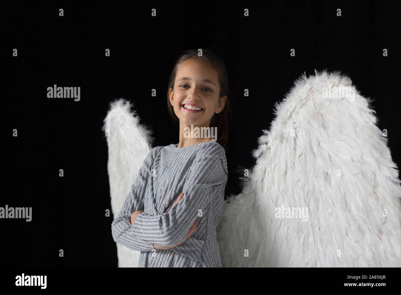 Portrait smiling, confident girl wearing angel wings Stock Photo