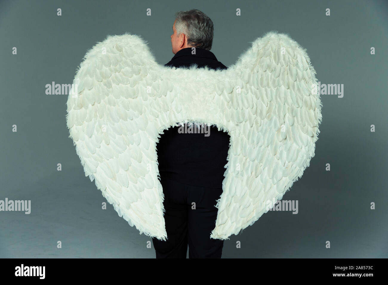 Serene man wearing angel wings Stock Photo