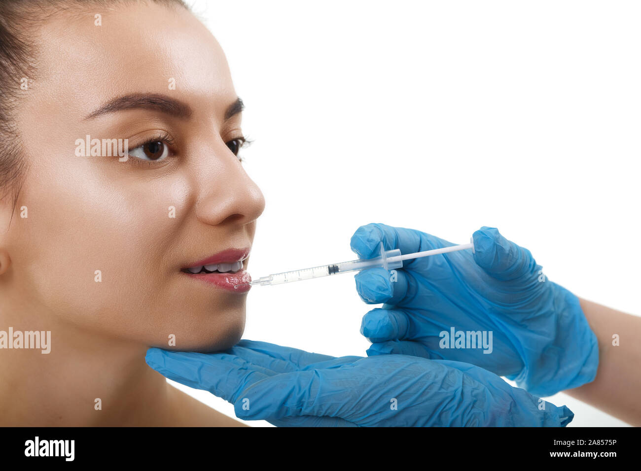 Facial Beauty Injections. Portrait Beautiful Young Woman Receiving Hyaluronic Acid Injection. Closeup Of Hands In Gloves Holding Syringe Near Stock Photo