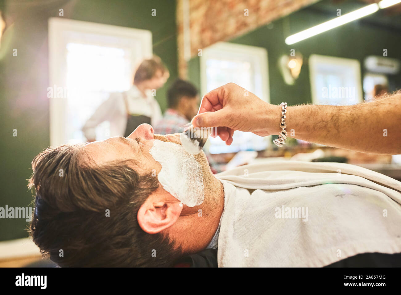 Man getting a shave at barbershop Stock Photo
