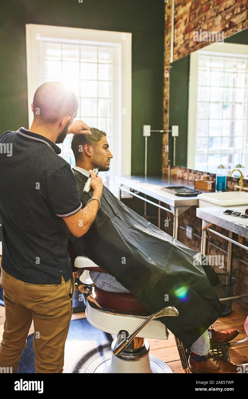 Man receiving haircut at barbershop Stock Photo