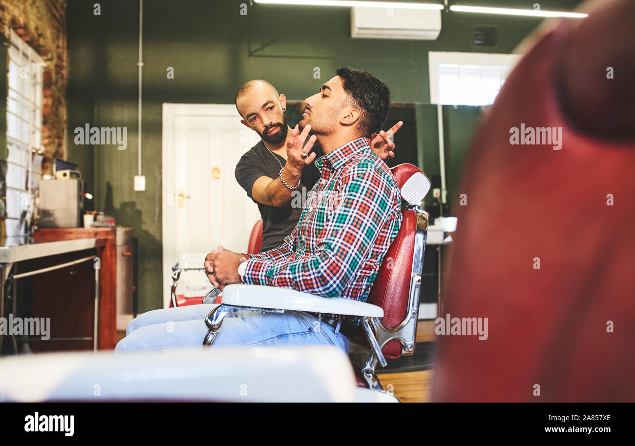 Male barber and customer in barbershop Stock Photo