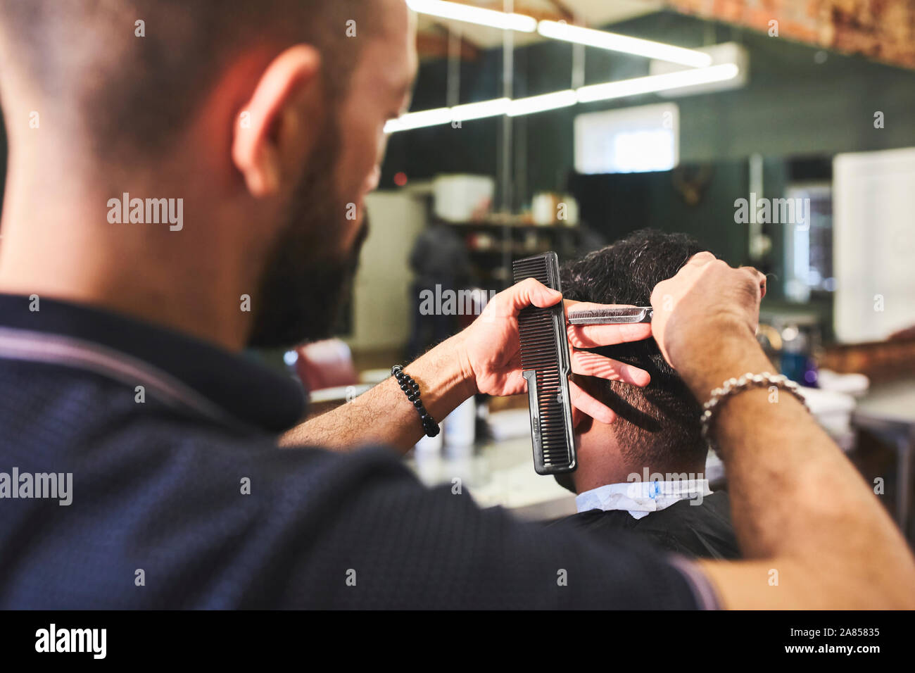 Male barber giving customer a haircut in Stock Photo Alamy