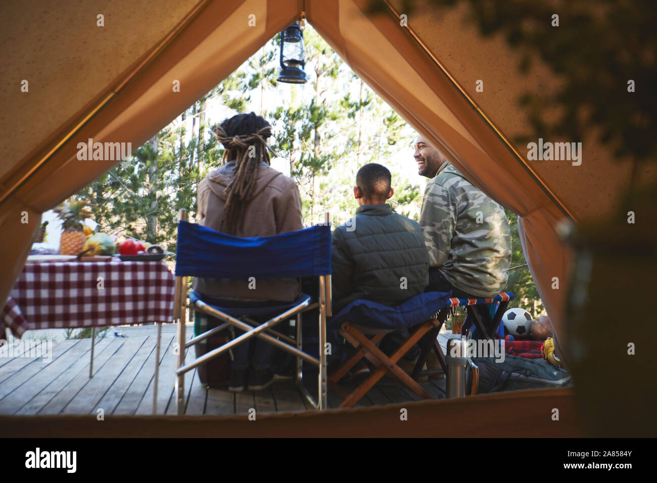 Family relaxing outside camping yurt Stock Photo