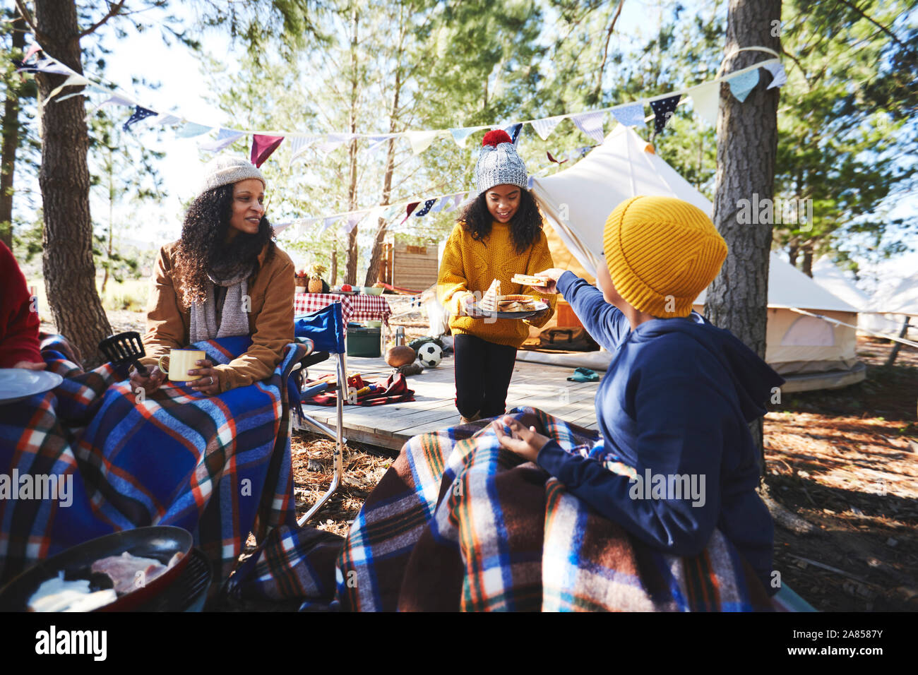 Family eating at campsite in woods Stock Photo