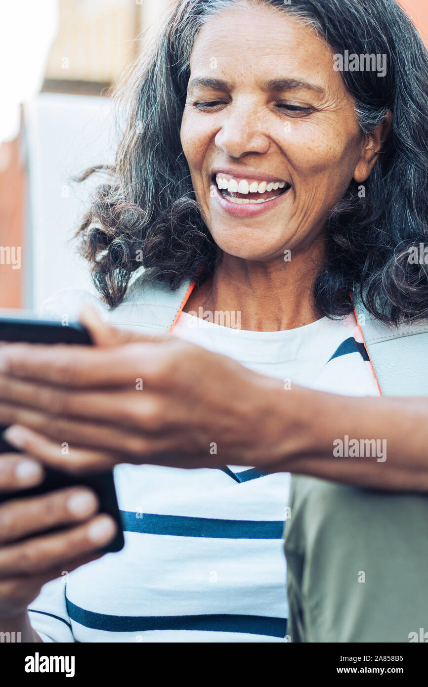 Smiling, happy woman using smart phone Stock Photo
