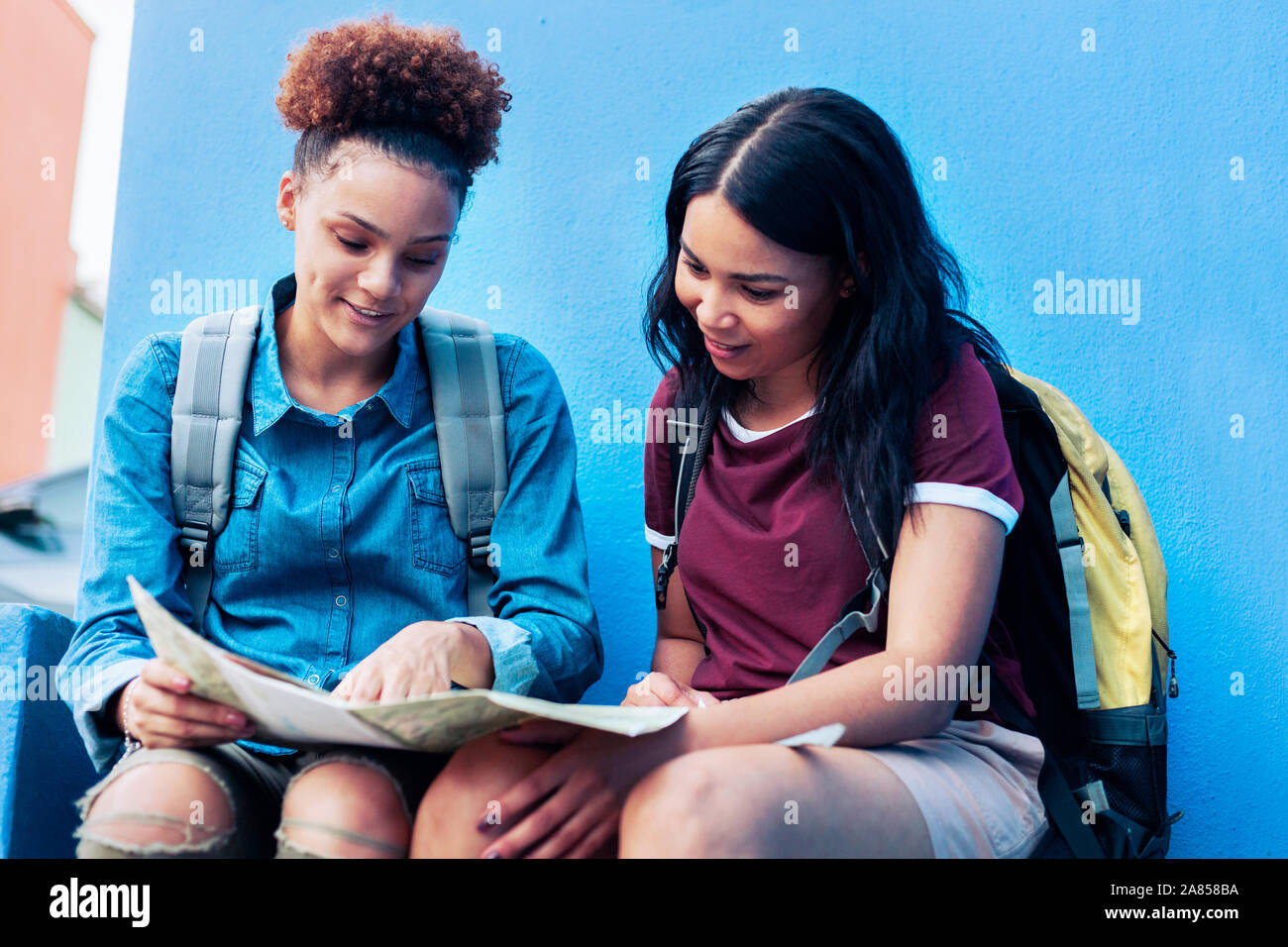 Young female backpackers looking at map Stock Photo