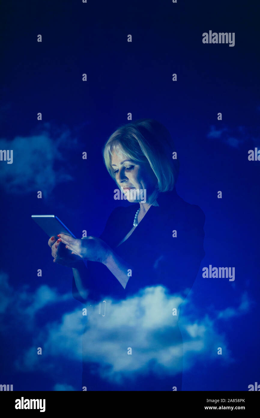 Double exposure businesswoman using digital tablet against blue sky with clouds Stock Photo