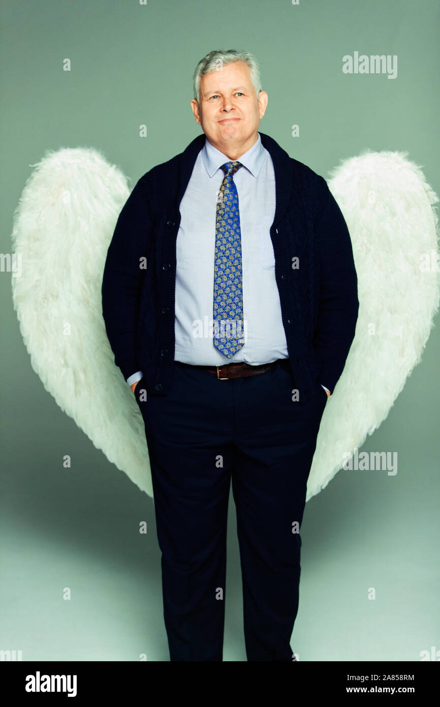 Portrait smiling businessman wearing angel wings Stock Photo