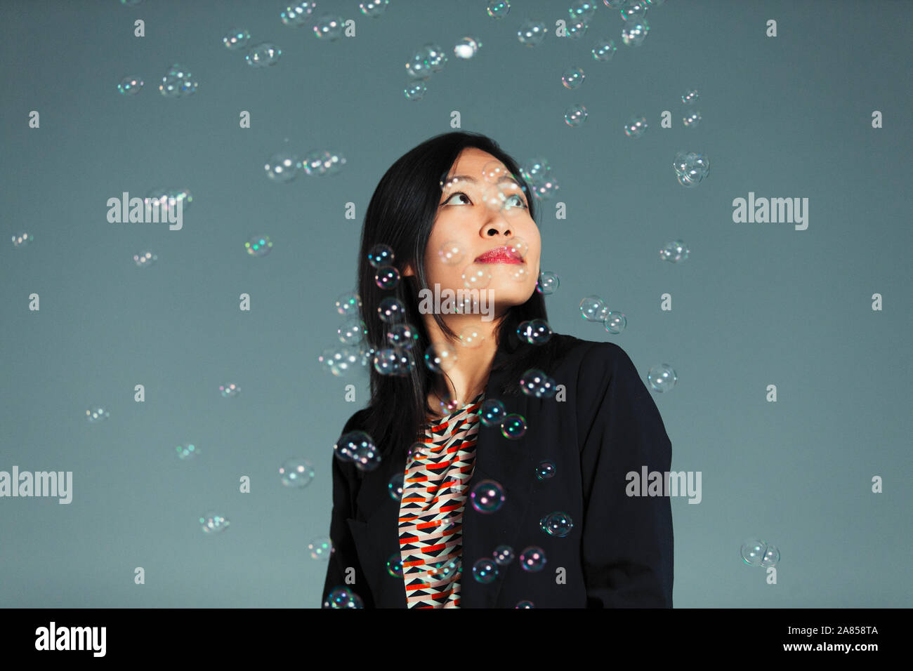 Bubbles falling around curious woman Stock Photo