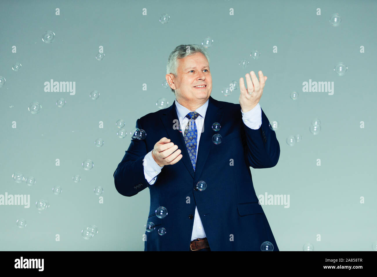 Playful businessman with bubbles Stock Photo