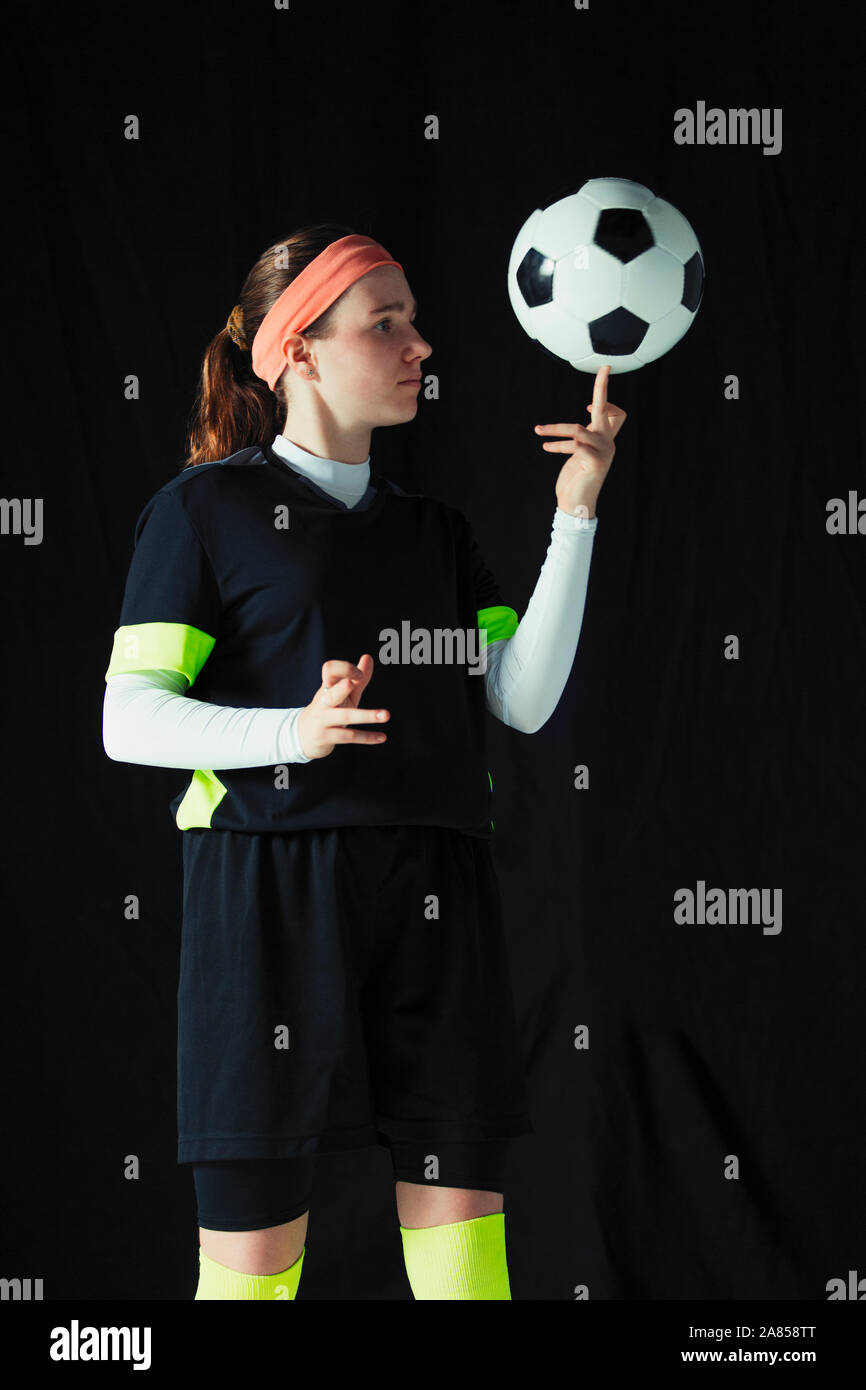 Teenage girl soccer player balancing soccer ball on finger Stock Photo