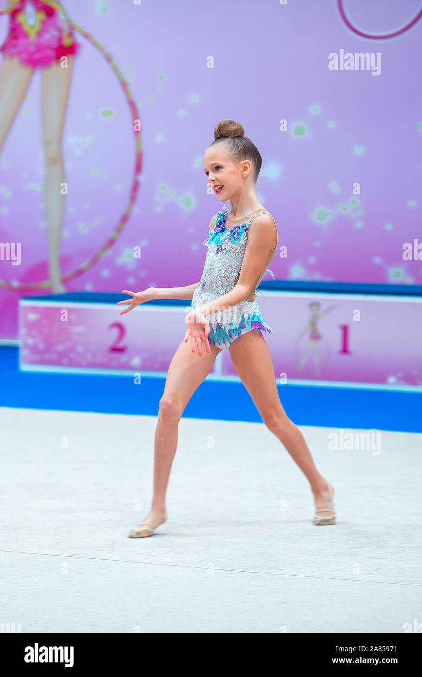 Beautiful little girl gymnast performs in competitions Stock Photo - Alamy
