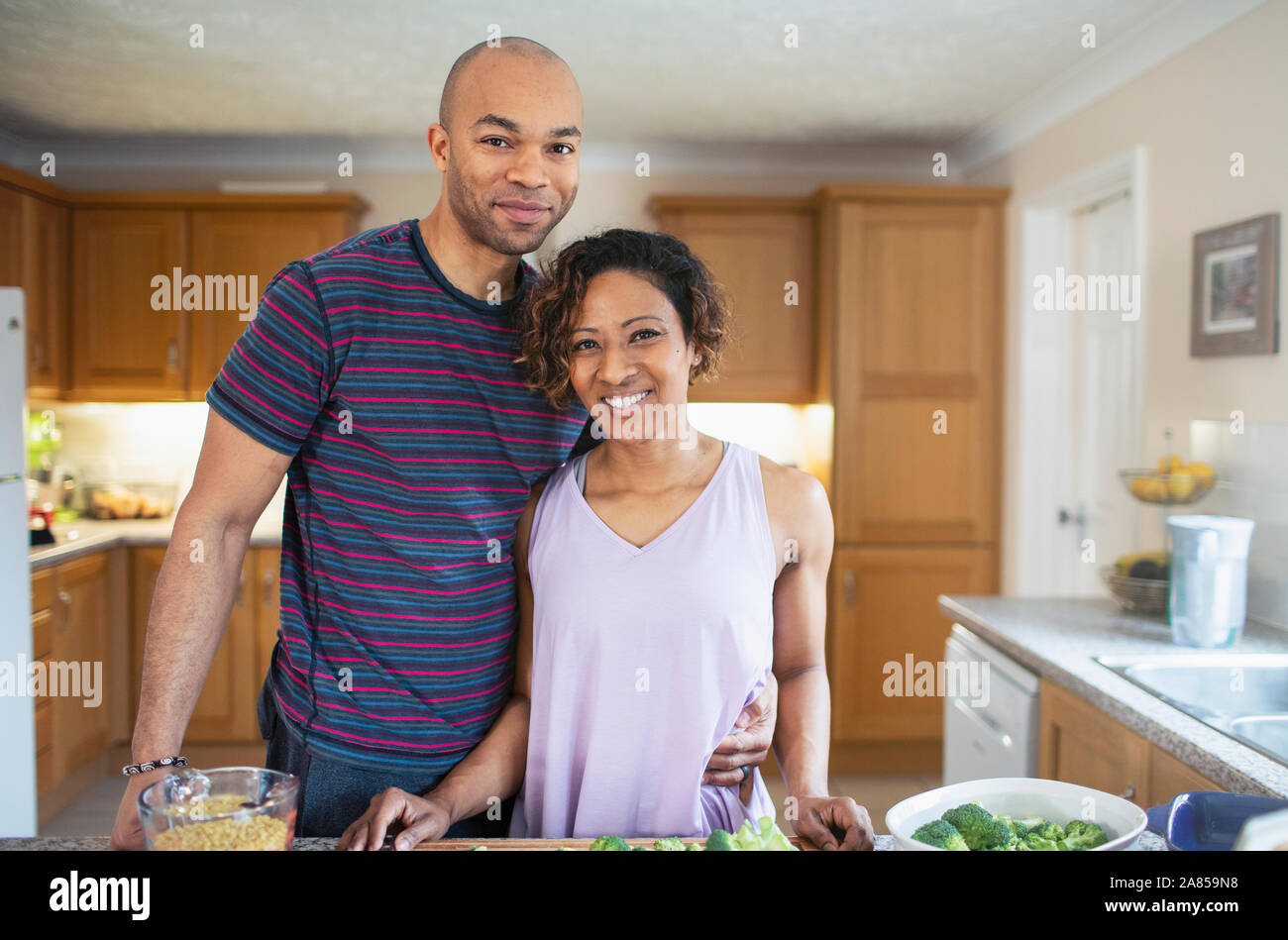Portrait smiling couple cooking in kitchen Stock Photo
