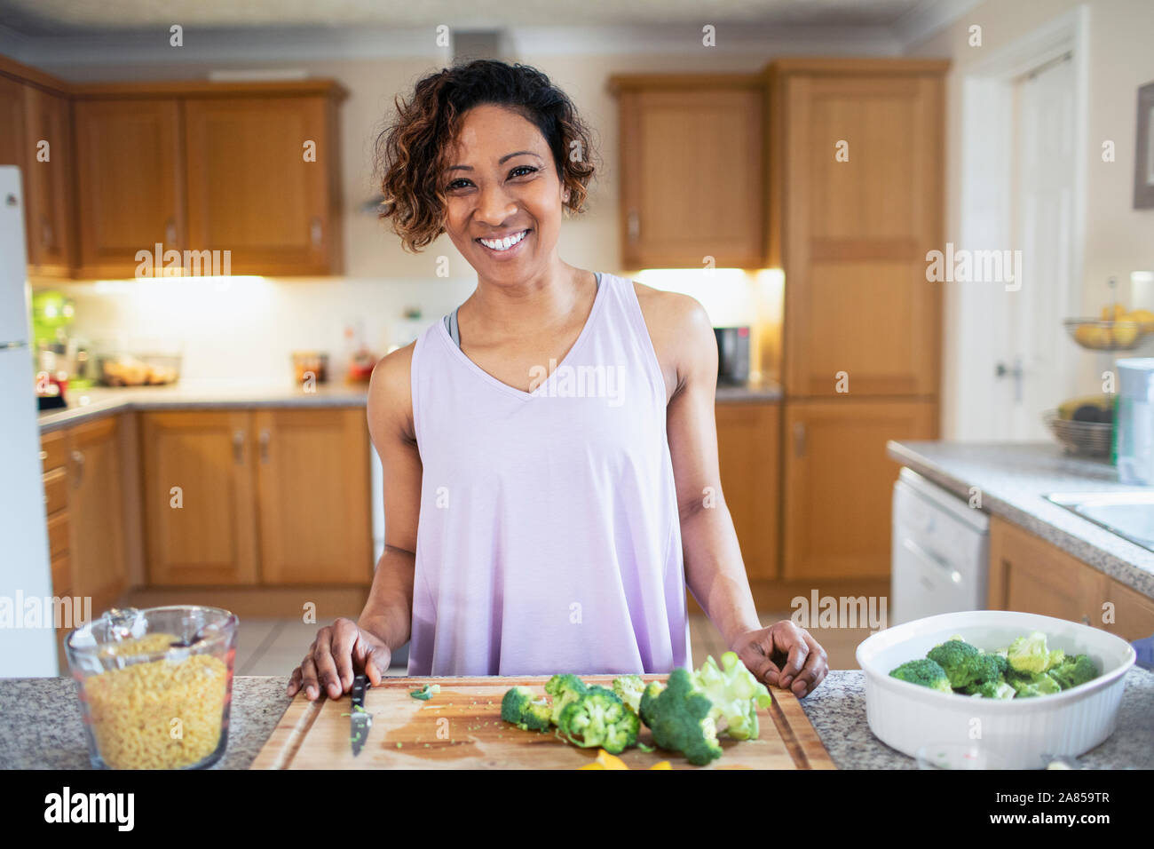 Portrait smiling, confident woman cooking in kitchen Stock Photo