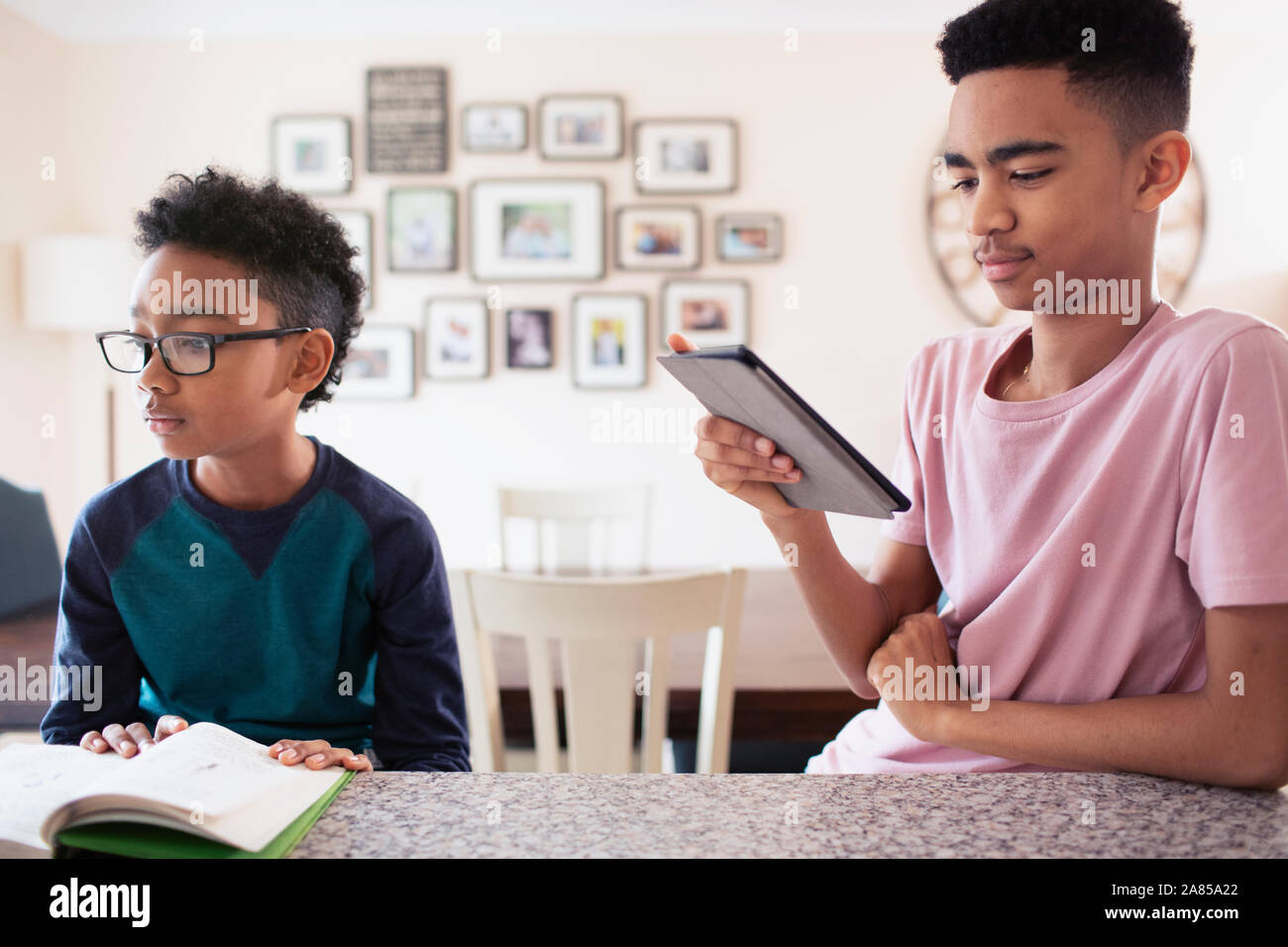 Brothers reading and using digital tablet in kitchen Stock Photo