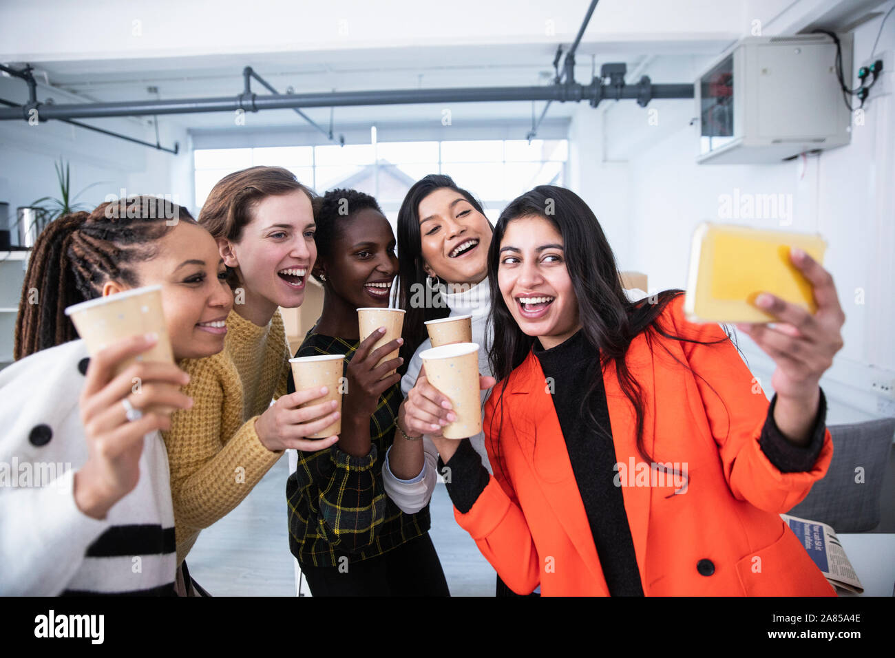 Happy businesswomen celebrating, taking selfie Stock Photo