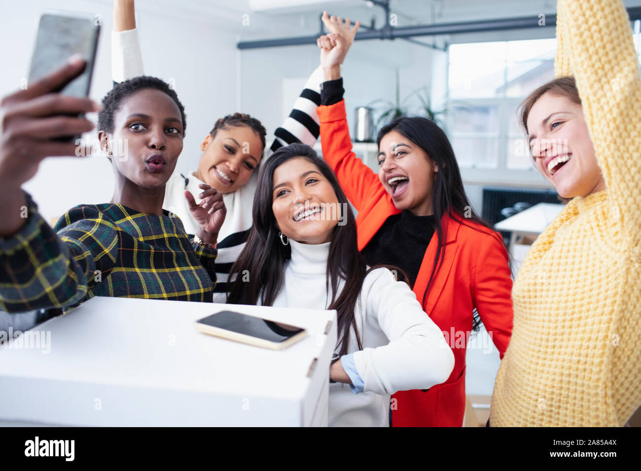 Happy businesswomen celebrating new office, taking selfie Stock Photo