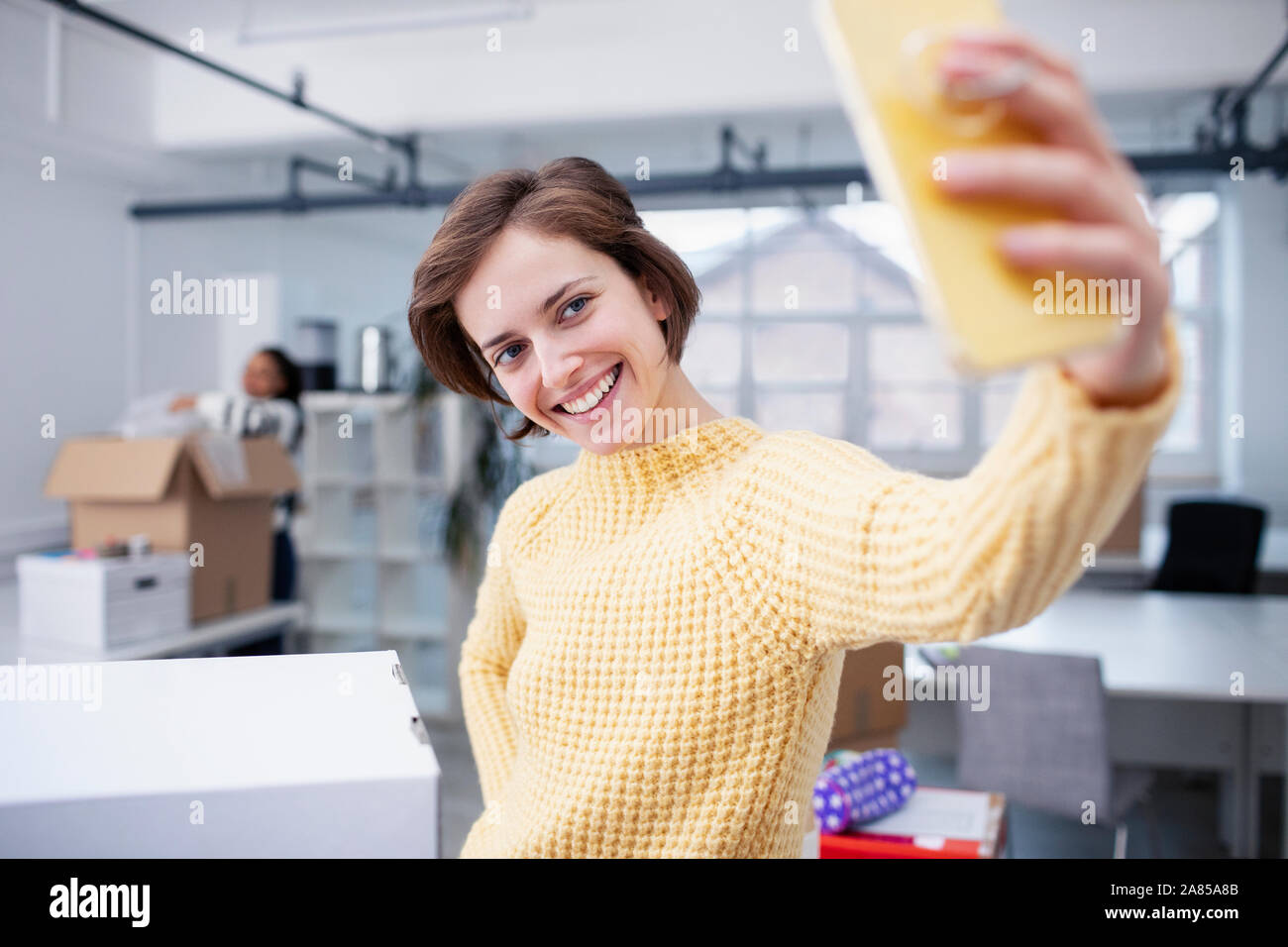 Confident businesswoman taking selfie in new office Stock Photo