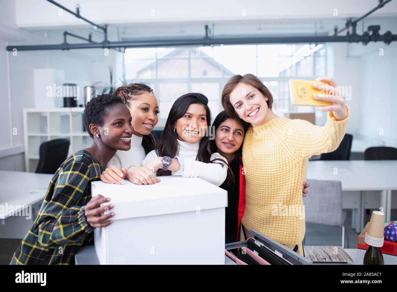 Businesswomen moving into new office, taking selfie Stock Photo