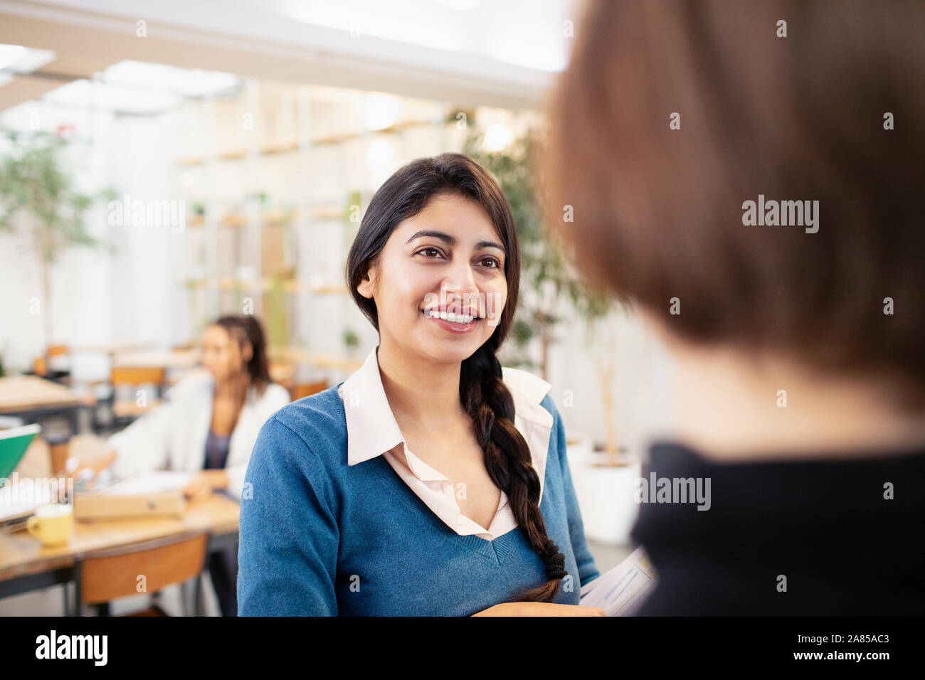Smiling businesswomen talking in office Stock Photo