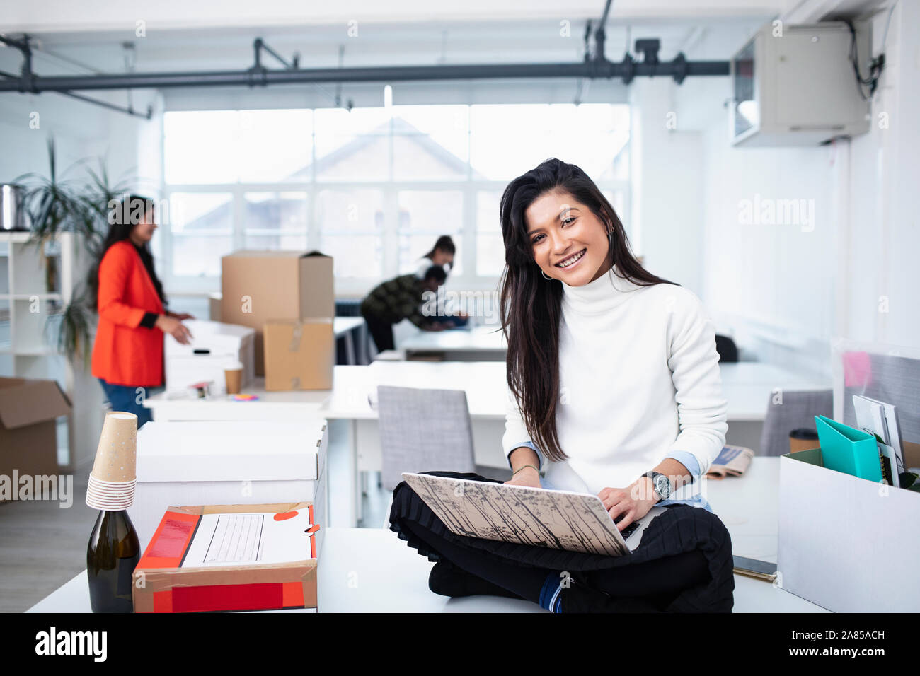 Portrait smiling, confident businesswoman using laptop in new office Stock Photo
