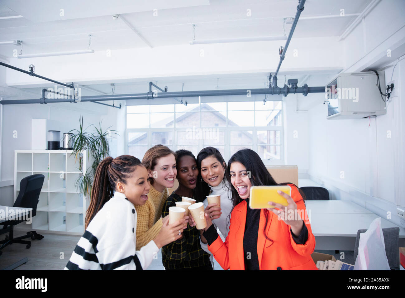 Businesswomen celebrating new office, taking selfie Stock Photo
