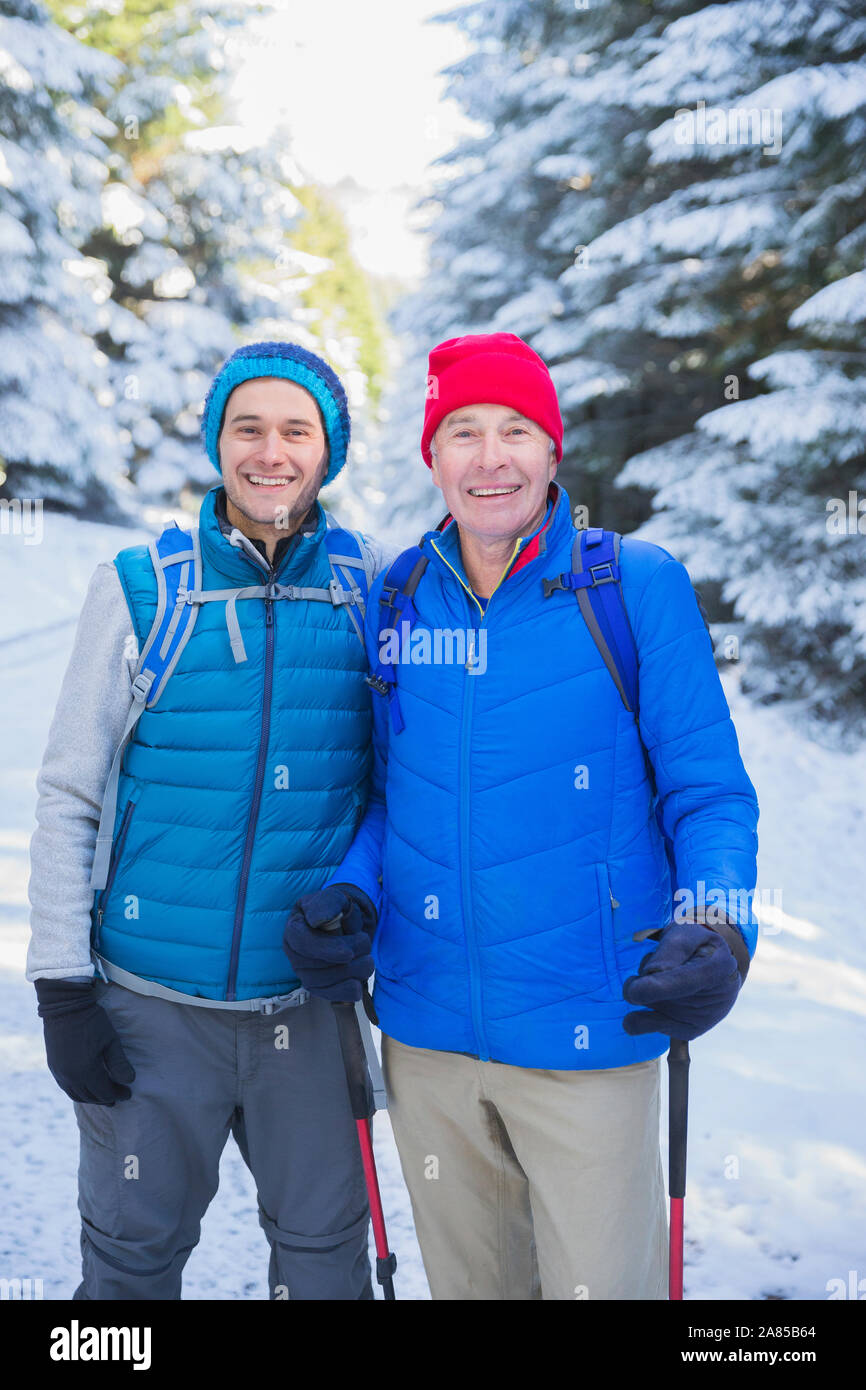 Portrait happy father and son hiking in snowy woods Stock Photo